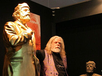 l'artiste uwe patzke, entouré de deux de ses créations, à la foire des